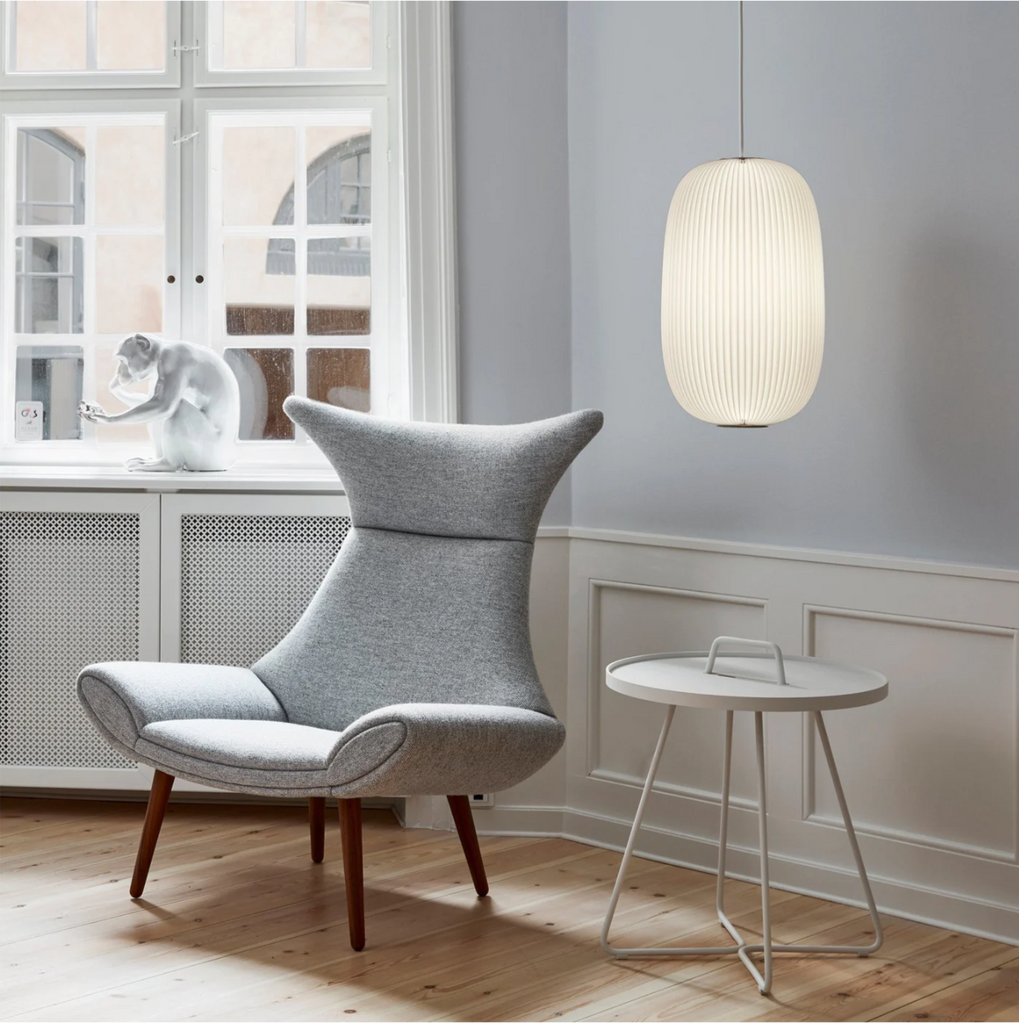la mella pendant light with gray chair in living room corner