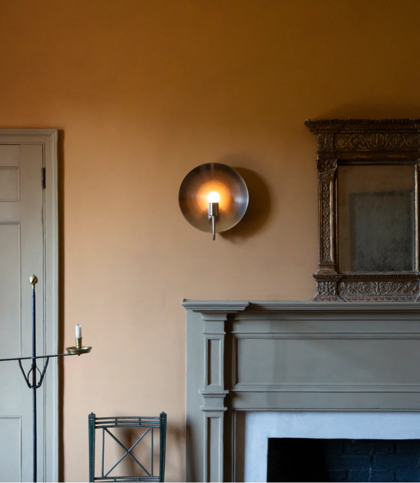 Helios ADA Sconce on wall next to fireplace