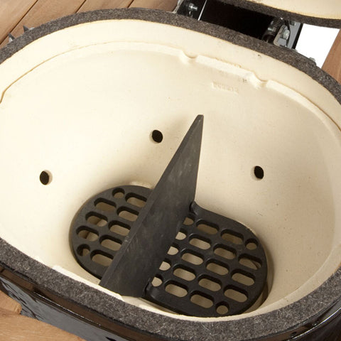 The Primo Large Oval Divider Plate sitting atop the lump grate inside the Large Primo Oval Grill's firebox.