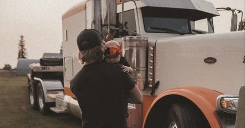 Jake Shellum with one of his daughters in front of big rig