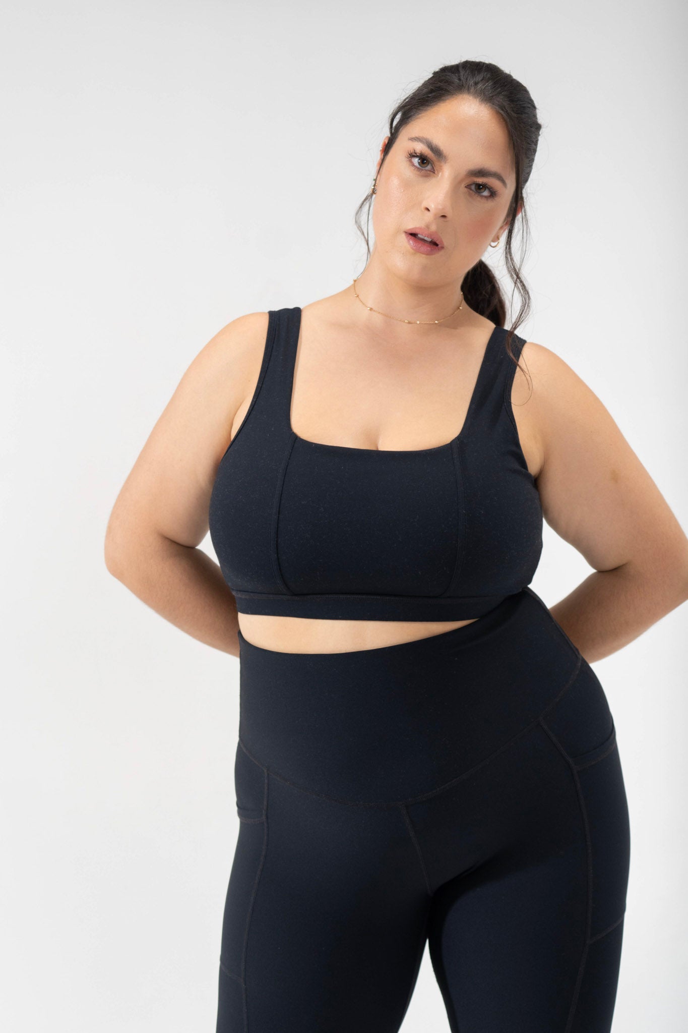 model wears plus size criss cross sports bra, cute activewear in black POPFLEX corset bra from the basics collection