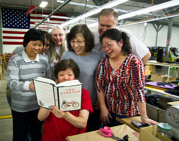 At the TOM BIHN factory in Seattle, the crew gets a first look at The $100 Startup by Chris Guillebeau