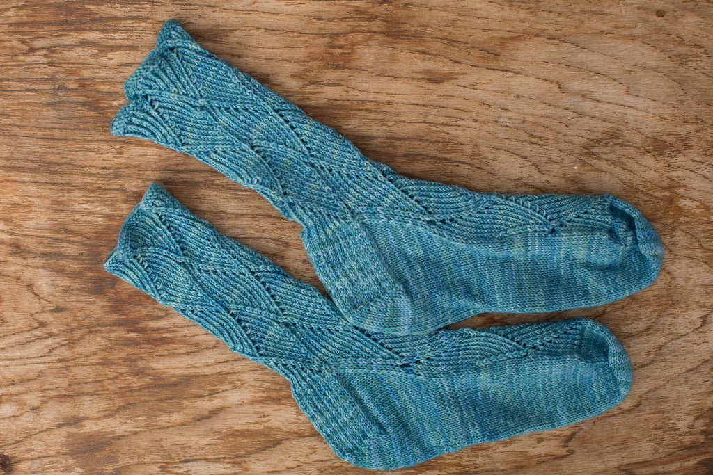 Turquoise blue lace knit socks. Handmade by the TOM BIHN Ravelry group for the TOM BIHN crew.