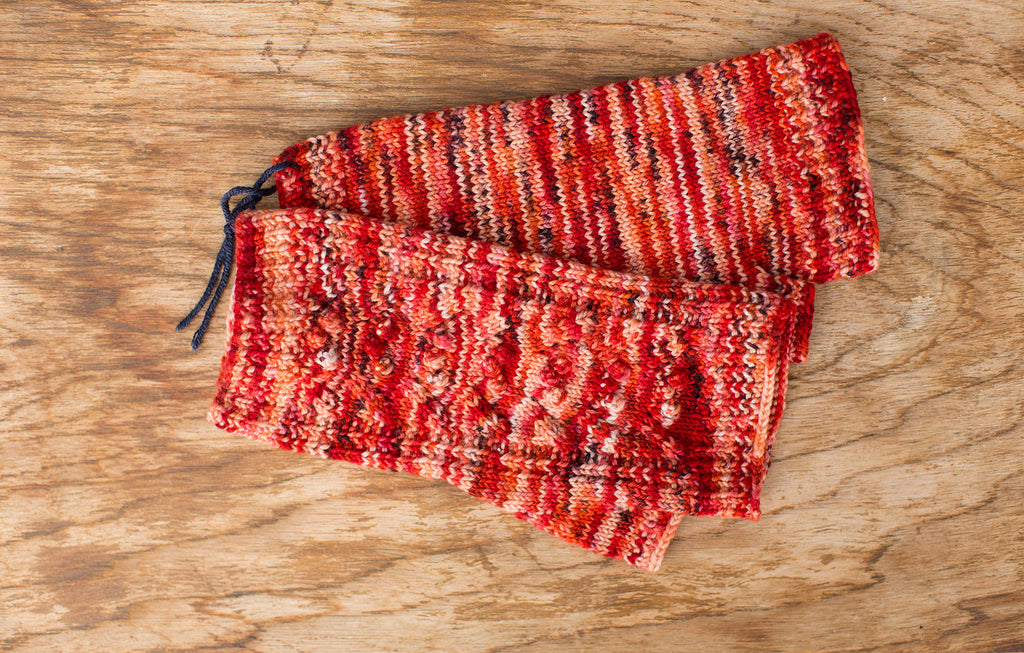 Multi-color red, orange, and white fingerless mittens. Handmade by the TOM BIHN Ravelry group for the TOM BIHN crew.