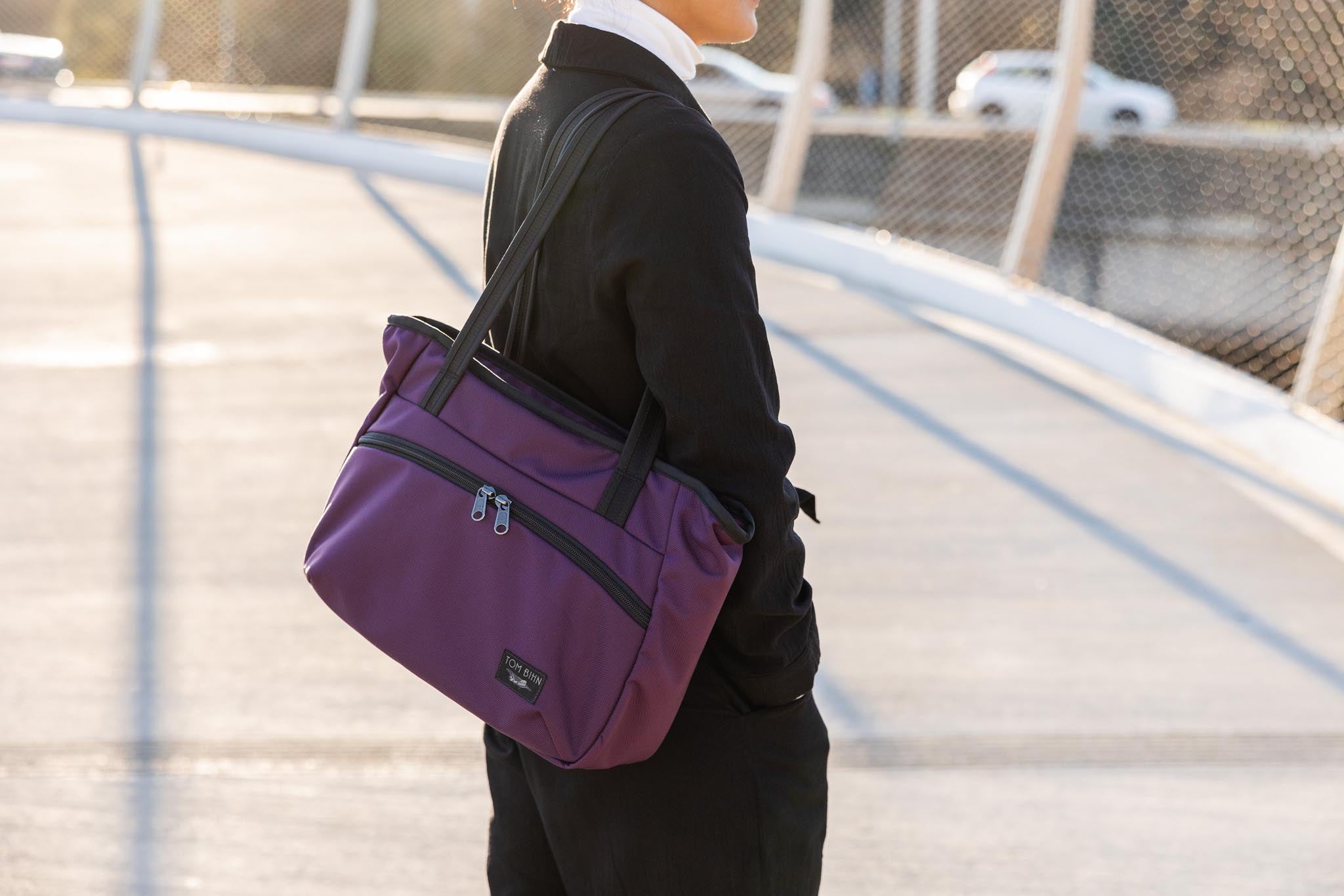 visible detail^^A perosn carrying a Nomad Tote over their shoulder.