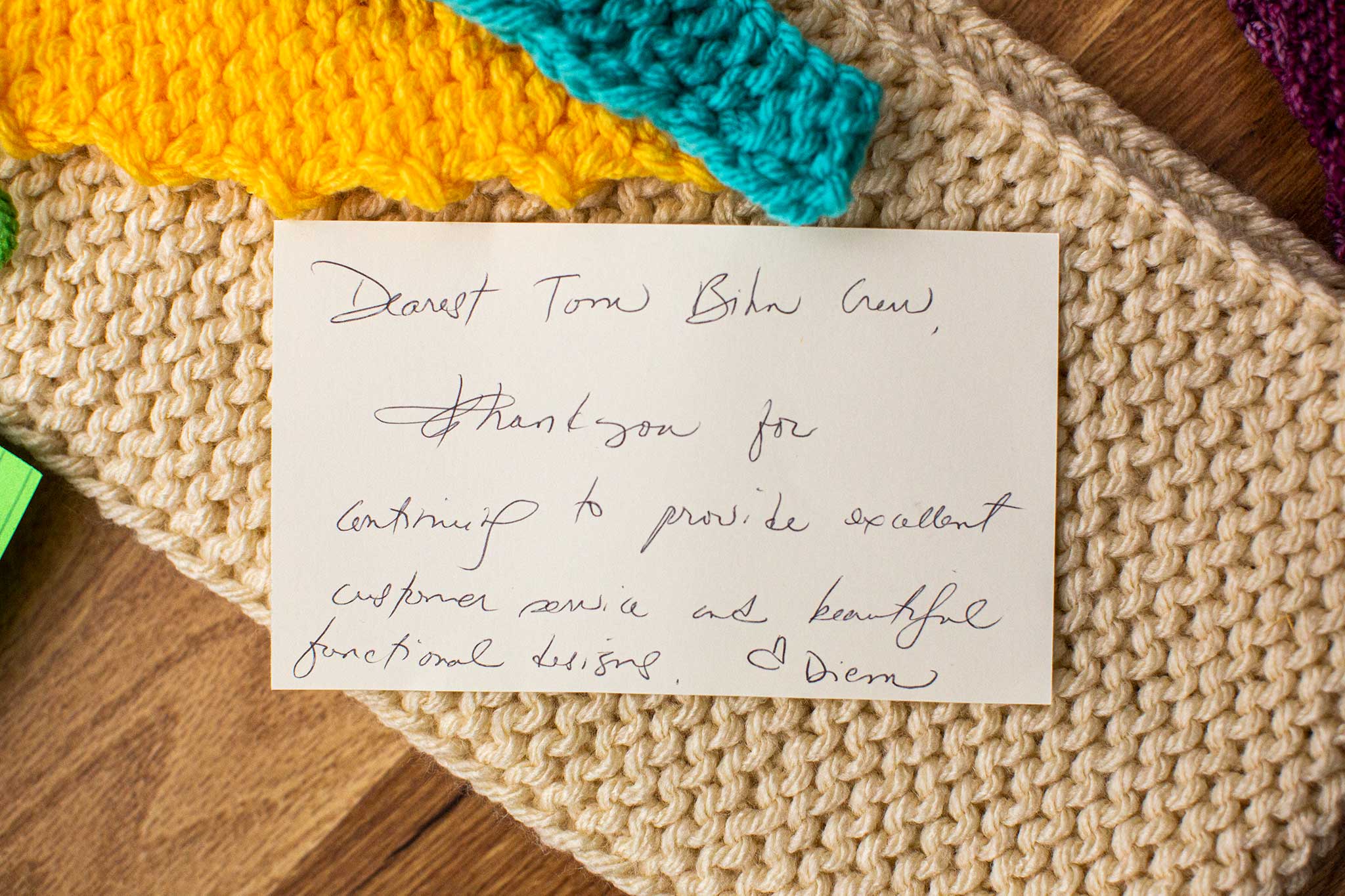 Close-up of a card attached to one of the crafted items. It says: "Dearest TOM BIHN Crew, thank you for continuing to provide excellent customer service and functional designs."