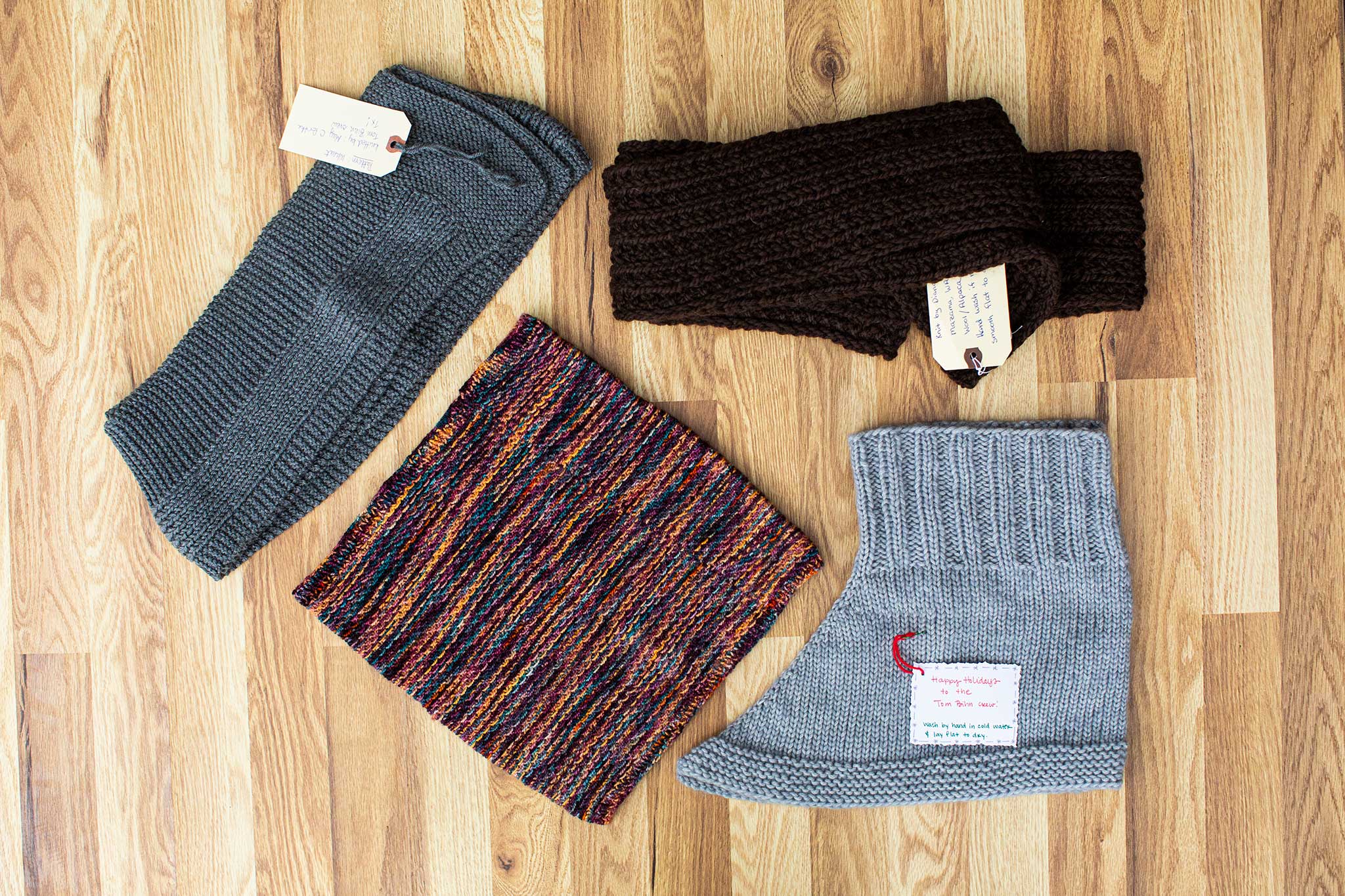 Various beautiful knitted cowls and scarves! Light grey, dark grey, chocolate brown, and a multitude of colors in a stripy pattern.