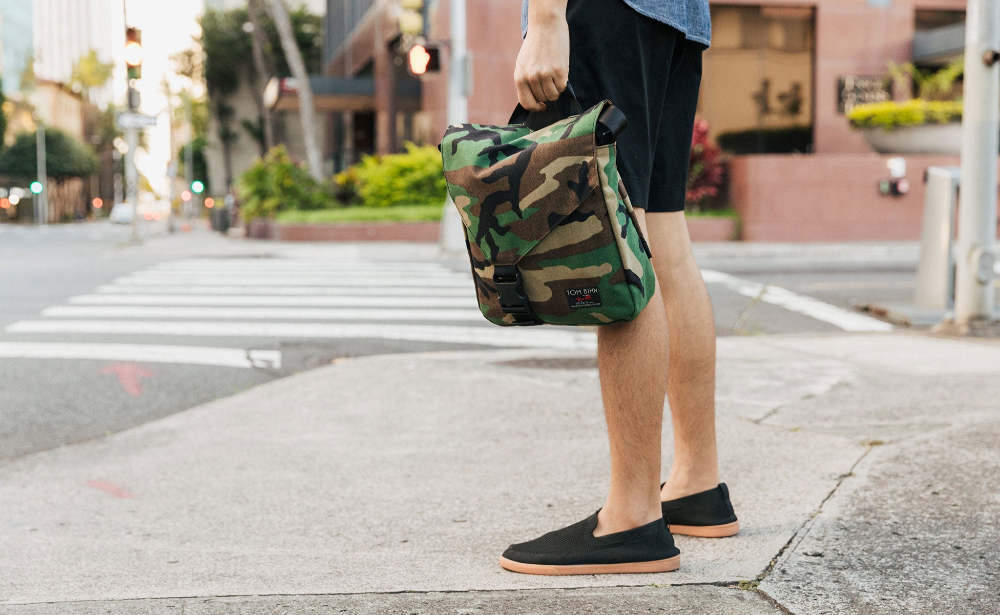 Person carrying a Medium Cafe Bag in Beaver Camo by its handle.