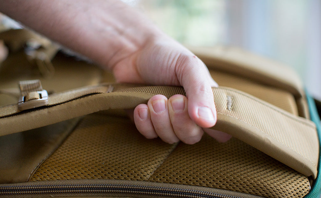 Man grabbing the Edgeless strap of a Synik 22; showing how thick and comfortable they are.