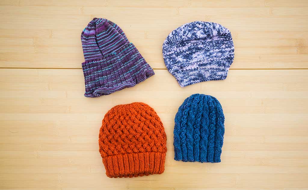 Colorful hats made for the TOM BIHN crew by the Ravelry group