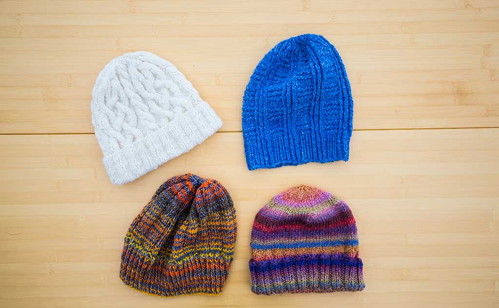 Colorful hats made for the TOM BIHN crew by the Ravelry group