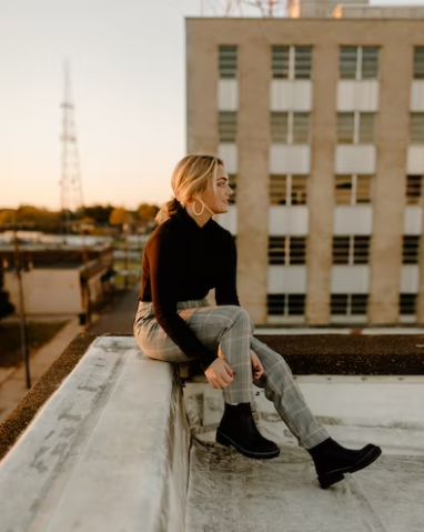 A woman wearing a black turtle neck and a checkered bottom. 