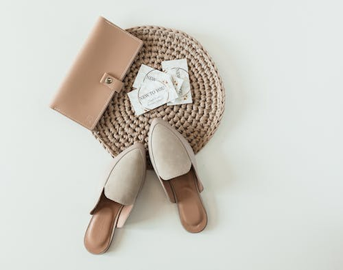  A pair of shoes and a purse laid out on a white background