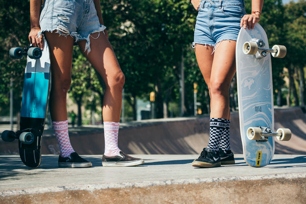 two girls holding longboards