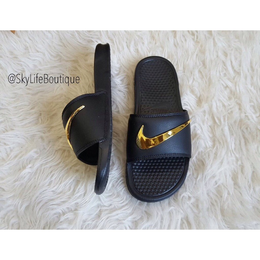 black nike slides with gold check