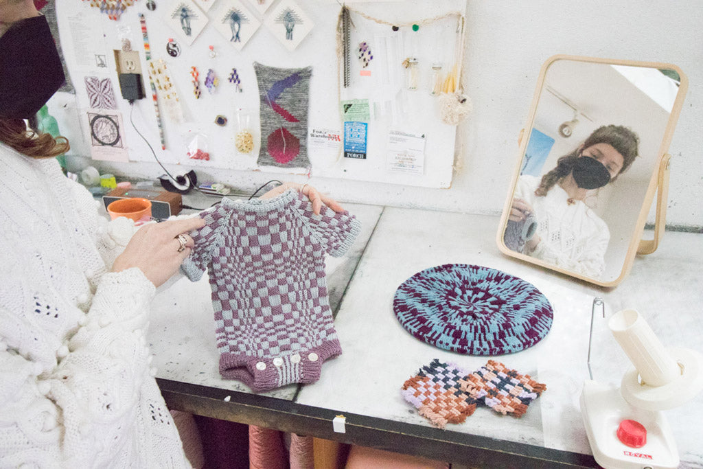 Elspeth Vance displays her knitted baby onesie