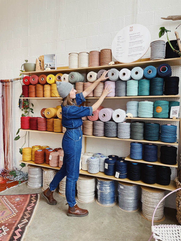 Modern Macramé Maker's Wholesale Program: Image depicts a shopper in front of a wall of rainbow rope