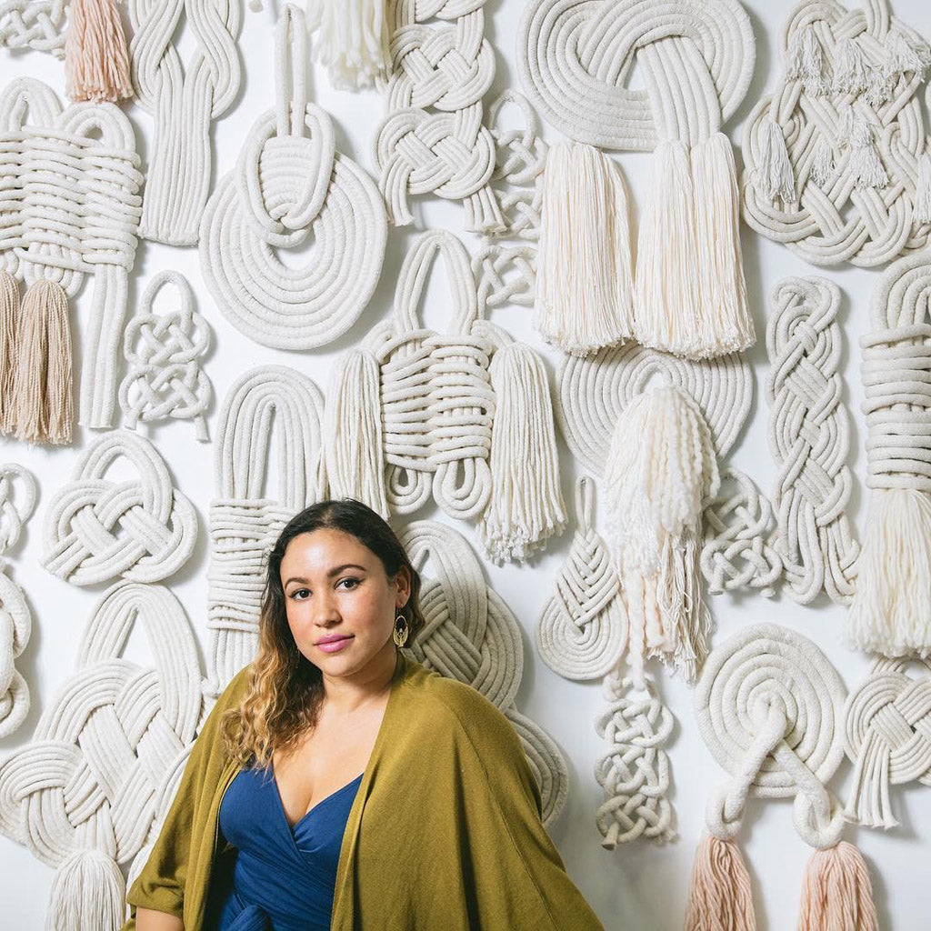 Lise Silva Gomes with a wall of her custom knots 