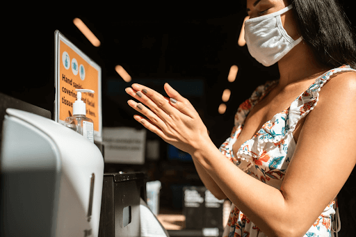 woman using hand sanitizer at a business