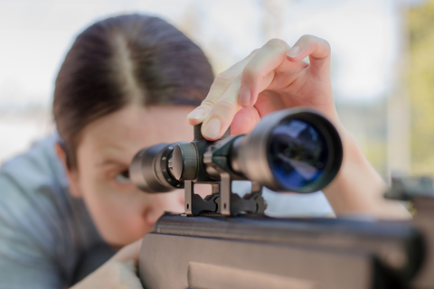 woman using scope on gun