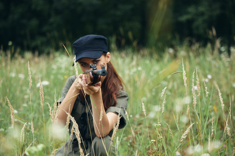 woman aiming gun while outdoors