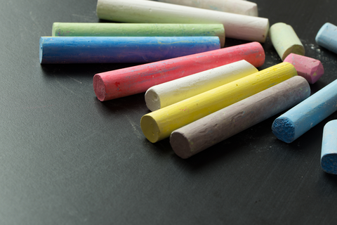 chalks of different colors on black surface