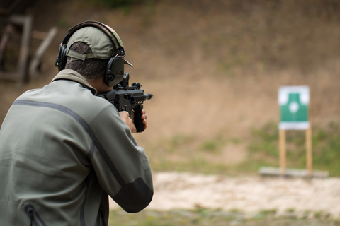 man aiming gun at shooting target