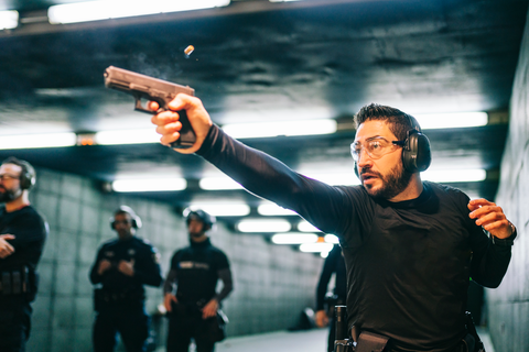 man at shooting range aiming at a target with pistol