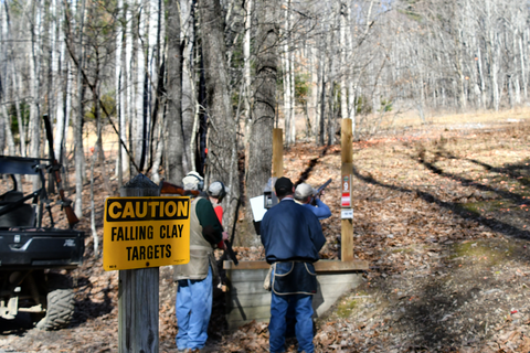 men at a clay shooting range aiming at clay targets