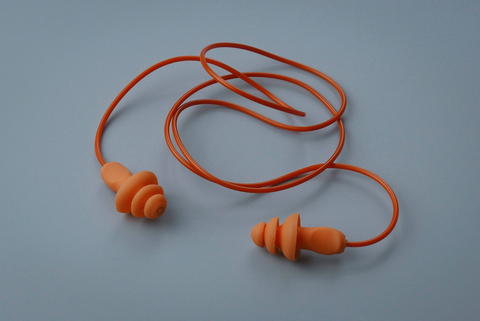 orange ear plugs on grey surface