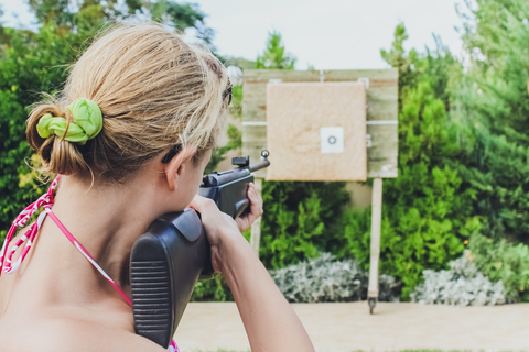 woman with shotgun aiming at shooting target