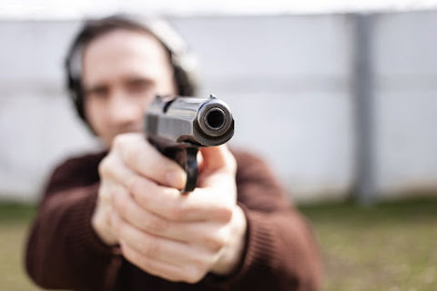 man pointing a gun with both hands