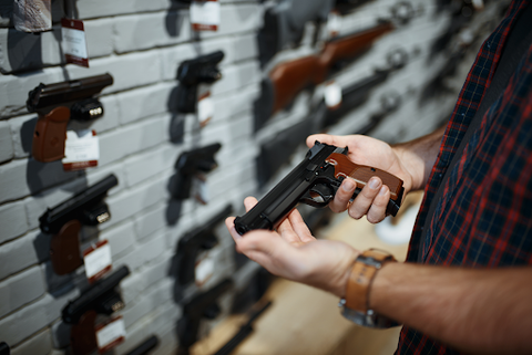 man looking at a gun in gun shop