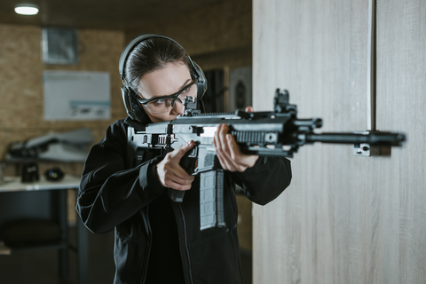 woman aiming shotgun at the shooting range
