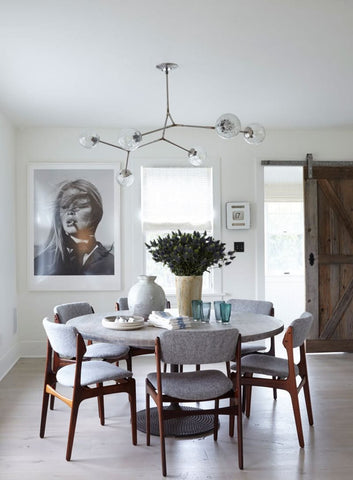 Dining room with a handmade vase on the table and old old barn door in background.