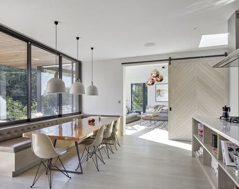 Kitchen and dining room with Eames dining chairs, bell pendant lamps and sliding door