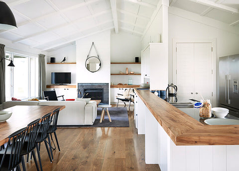 White living and dining room with timber floor, timber dining table and white sofa