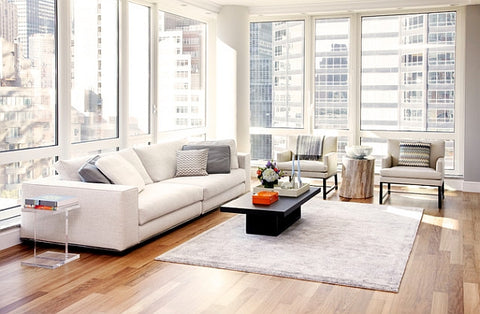 Minimalist apartment living room interior with floor to ceiling windows, white sofa, acrylic side table and black coffee table