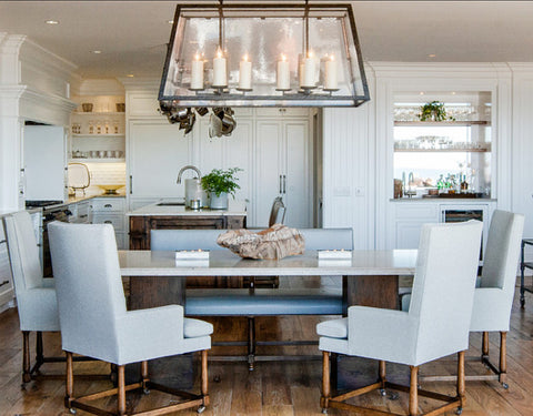 Transitional kitchen and dinning interior with white cabinets, grey dinning chairs and rectangular candle chandelier