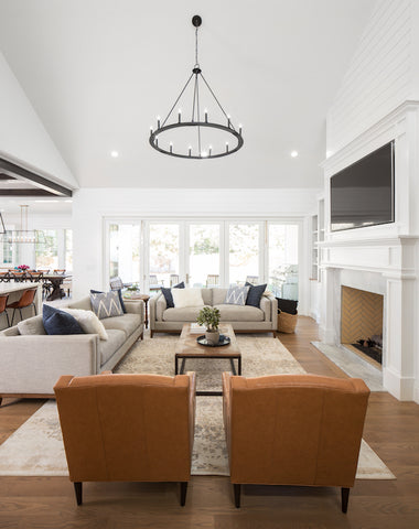 Living room with orange armchairs, fireplace, TV and modern Chandelier