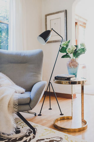 living room with grey armchair, floor lamp and gold side table