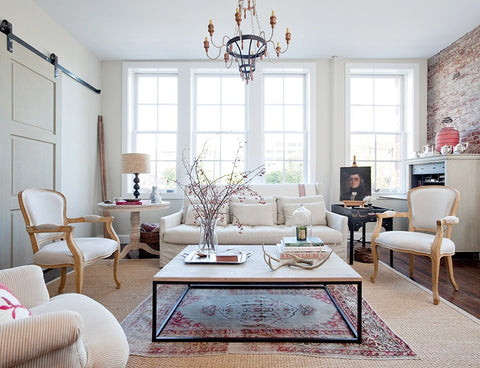 Living room with brick wall, Victorian chairs and chandelier