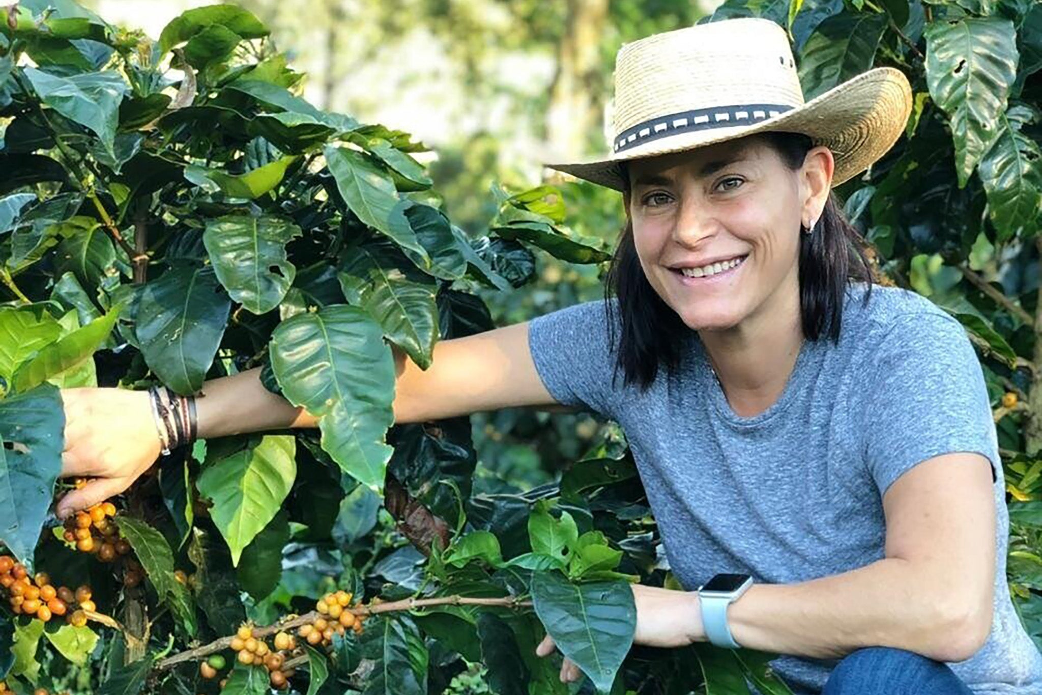 Eleane Mierisch beside a coffee cherry tree