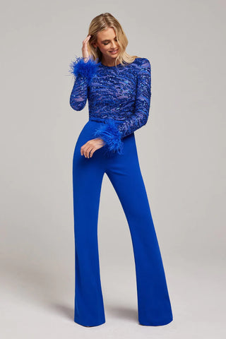 Woman wearing long-sleeved blue jumpsuit with embellished beaded sequins