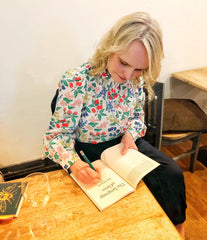 Rae Howells signing a copy of her poetry collection. 