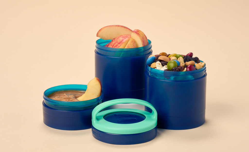 A blue Whiskware Snack Container filled with healthy snacks on a plain white background.