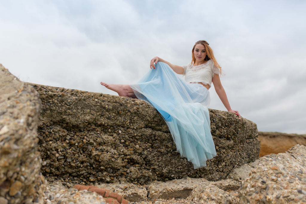 Bride sitting on a beach wall