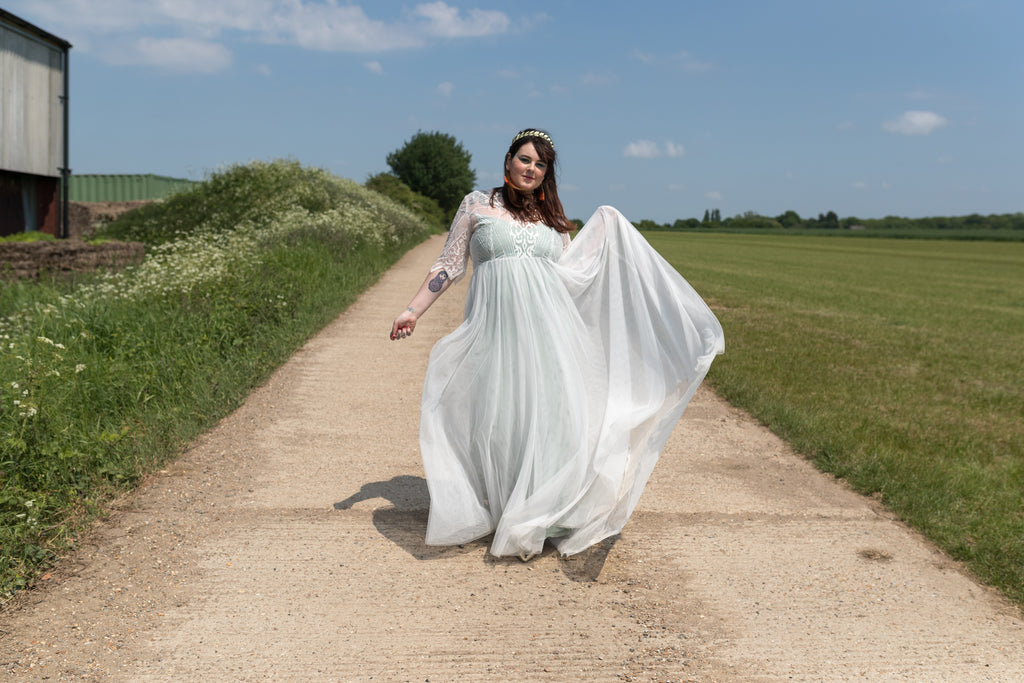 Bride swooshing her wedding dress