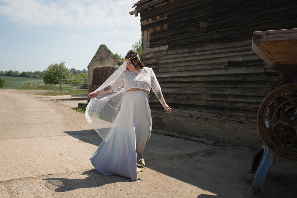 Beautiful bride with a fantastic lace veil in a farm setting