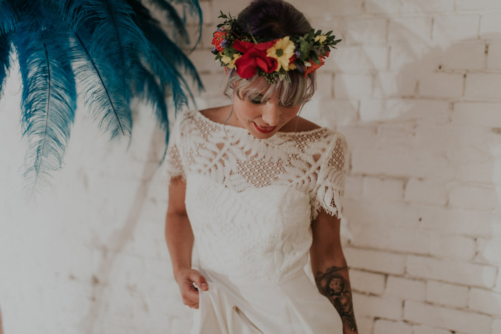 A beautiful boho bride admiring her wedding dress